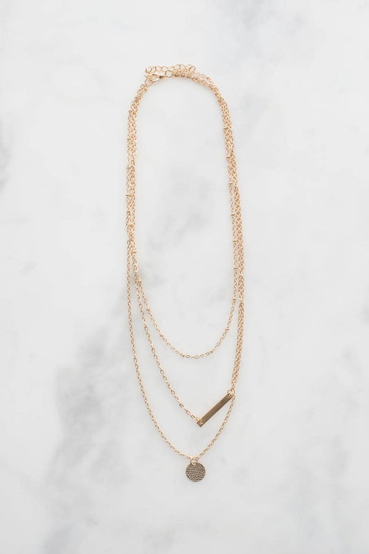 Dainty gold necklace with two pendants on a white background